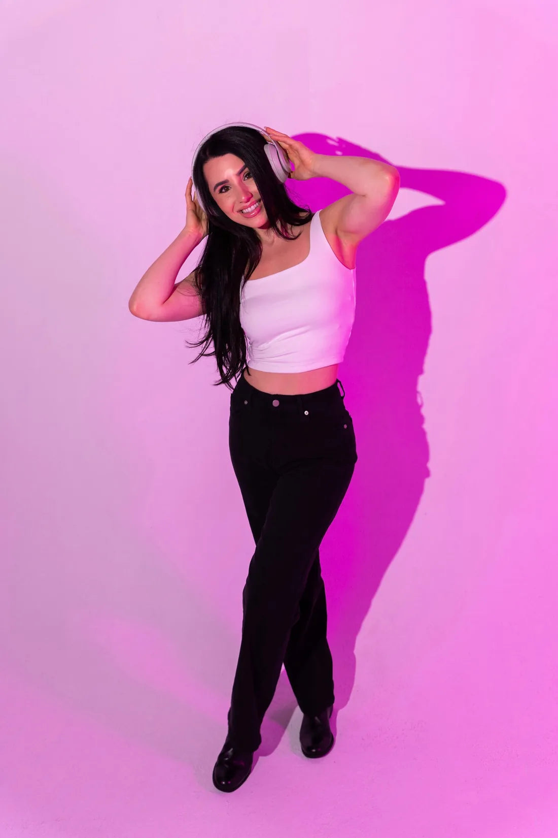 Rachel in headphones under hot pink studio light